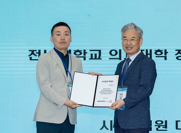 정유진 교수(왼쪽)가 김원 대한응급의학회 회장으로부터 김승호 학술상을 받고 있다.